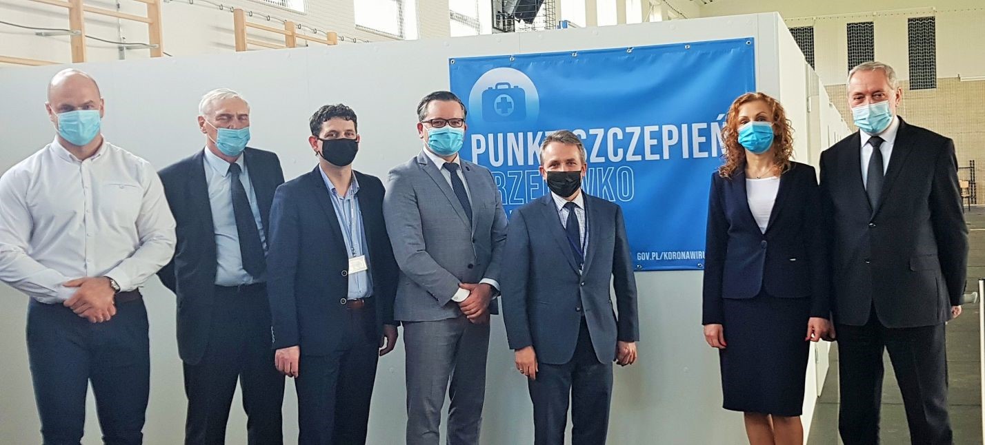 7 osób na tle punktu szczepień