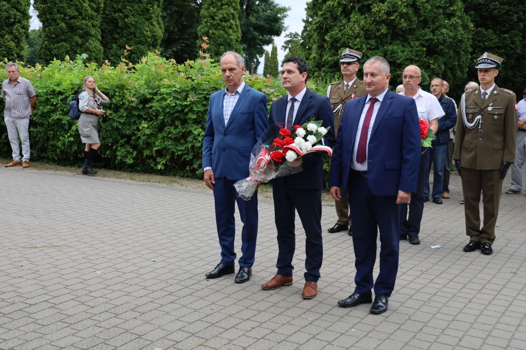 Zastępca Burmistrza Daniel Choinka, Przewodniczący Rady Maista Robert Krajewski oraz Wiceprzewodniczący Bogusław Konrad składają kwiaty w hołdzie powstańcom warszawskim
