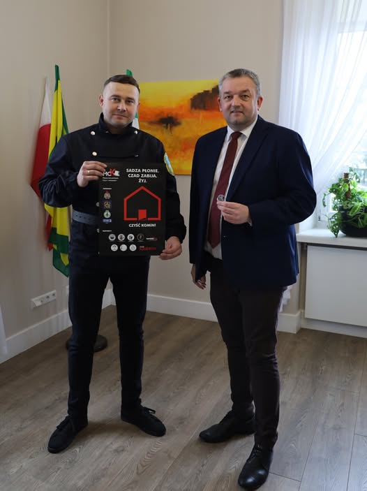 DWUCH MĘŻCZYZN JEDEN STOI Z PLAKATEM DRUGI TRZYMA GUZIK 